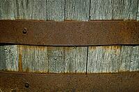 A close-up of an old wooden barrel held together with rusty metal hoops. weathered wood backdrop for garden, rustic charm, or other creative backgrounds [IBR125026210]