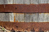 A close-up of an old wooden barrel held together with rusty metal hoops. weathered wood backdrop for garden, rustic charm, or other creative backgrounds [IBR125026212]