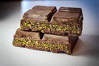 Dubai chocolate with pistachio cream filled center. sliced and stacked for presentation. macrophotography close-up background [IBR125026214]