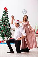 Young pair celebrating christmas at home [IBR125053204]