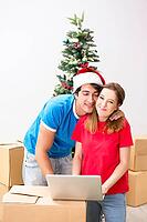 Young family celebrating christmas in new home [IBR125053219]