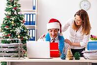 Colleagues exchaing christmas presents in office [IBR125053222]