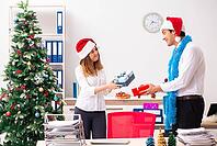 Colleagues exchaing christmas presents in office [IBR125053225]
