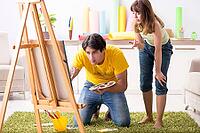 Young couple enjoying painting at home [IBR125053253]