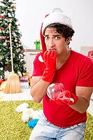 Man cleaning his apartment after christmas party [IBR125053263]
