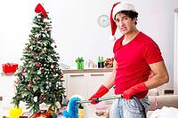 Man cleaning his apartment after christmas party [IBR125053264]