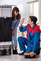 Man repairing fridge with customer [IBR125062171]