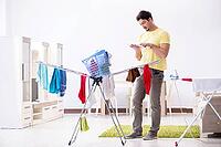 Handsome man husband doing laundering at home [IBR125062180]