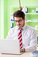 Despaired businessman thinking of suicide in the office [IBR125062182]