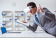 Businessman with virtual reality glasses in the office [IBR125062227]