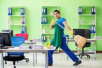 Young male handsome professional cleaner cleaning floor with broom [IBR125062244]