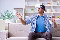 Man with virtual reality glasses playing at home [IBR125062246]