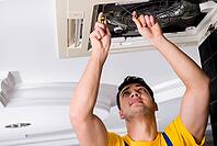 Repairman repairing ceiling air conditioning unit [IBR125062250]