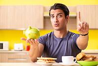 Young man in unhealthy food concept [IBR125075741]