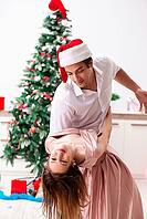 Young pair celebrating christmas at home [IBR125075747]