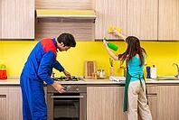 Woman with contractor at kitchen discussing repair [IBR125075749]