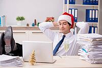 Young worker working in office on christmas shift [IBR125075773]
