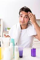 Young handsome man in the bathroom in hygiene concept [IBR125075778]