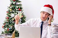 Young worker working in office on christmas shift [IBR125075784]