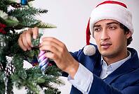Young employee celebrating christmas at workplace [IBR125075795]