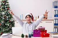 Young employee businessman in office christmas concept [IBR125075796]