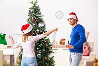 Young family celebrating christmas at home [IBR125075797]