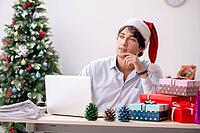 Young employee businessman in office christmas concept [IBR125075799]