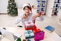 Young employee businessman in office christmas concept [IBR125075803]