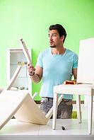 Man repairing furniture at home [IBR125094356]