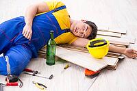 Floor repairman drinking alcohol during break [IBR125094370]