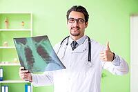 Doctor radiologist looking at x-ray scan in hospital [IBR125094371]