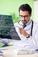 Doctor radiologist looking at x-ray scan in hospital [IBR125094372]