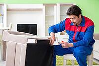 Repair contractor repairing broken furniture at home [IBR125094374]