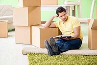 Young handsome man moving in to new house with boxes [IBR125094375]