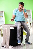 Man repairing furniture at home [IBR125094393]