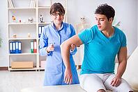 Doctor checking nerve reflexes with hammer [IBR125094403]