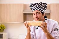Young male baker working in kitchen [IBR125118025]