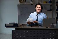 Young male architect working night at office [IBR125118028]