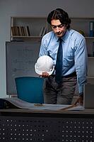 Young male architect working night at office [IBR125118031]