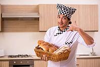 Young male baker working in kitchen [IBR125118033]