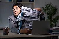 Young male employee working late at office [IBR125118035]