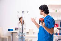 Young male foctor and female patient in blood transfusion concept [IBR125118037]
