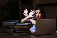 Young female student preparing for exams late at home [IBR125141693]