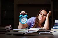 Young female student preparing for exams late at home [IBR125141695]