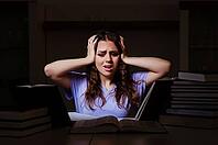 Young female student preparing for exams late at home [IBR125141698]