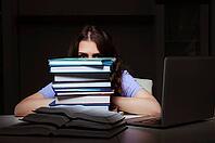 Young female student preparing for exams late at home [IBR125141699]