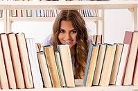 Young female student preparing for exams at library [IBR125141703]