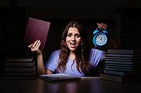 Young female student preparing for exams late at home [IBR125141710]