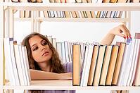 Young female student preparing for exams at library [IBR125141712]