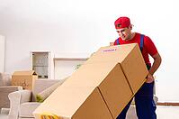 Young contractor with boxes working indoors [IBR125141732]